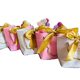 Combo de velas artesanales en forma de flor, presentadas en sobres decorativos con lazo dorado, ideales para regalo